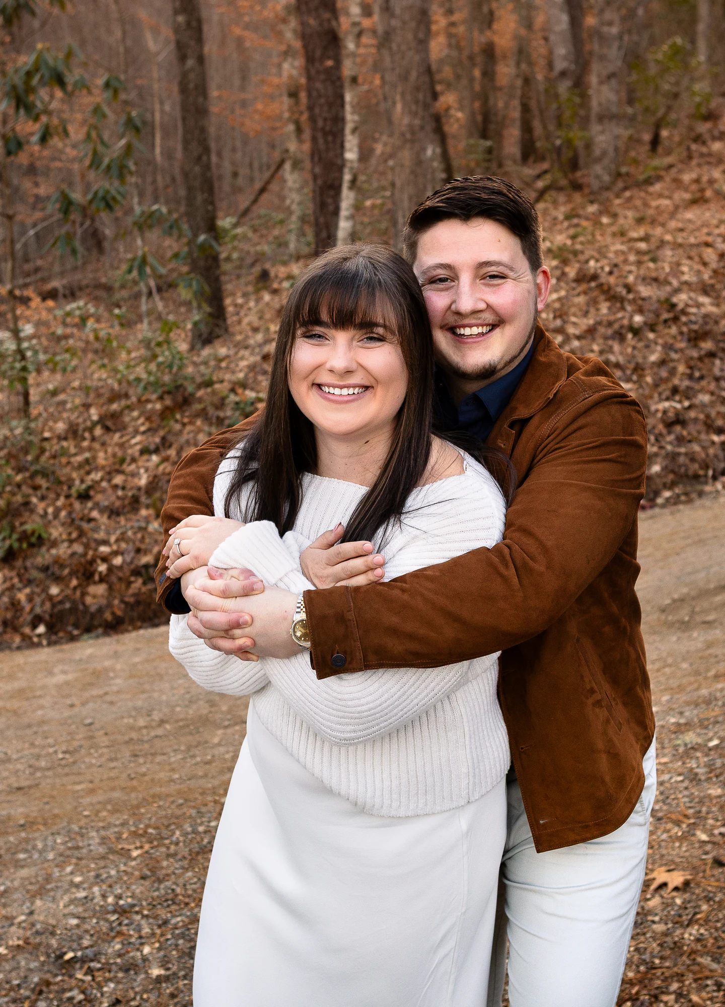 Gage and Riley smiling together on a mountain road